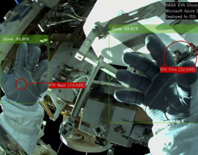 A close-up of a glove with text including NASA EVA Glove and other percentage data visible.