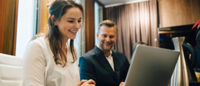 A man and woman looking at a laptop.