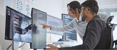 A man and woman pointing at a computer screen.