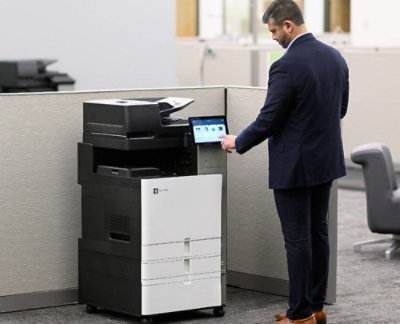 A man in a suit standing next to a printer.