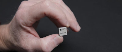 A person holding a small square object in their fingers.
