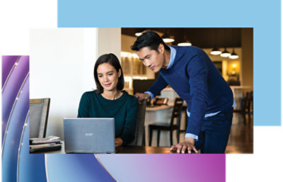 A man and woman looking at a laptop.