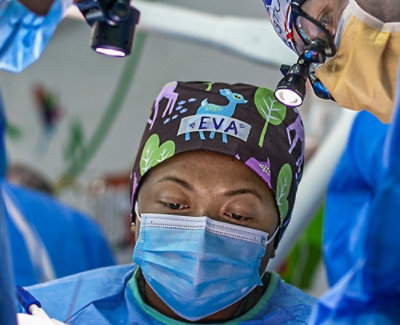A close-up of a woman wearing a surgical mask with text reading EVA.