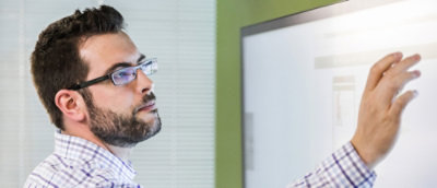A guy writing on a whiteboard
