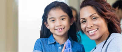 Child and caregiver smiling together.