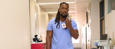 Nurse using smartphone in hospital hallway
