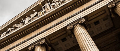 Historic building facade featuring tall columns and decorative carvings.