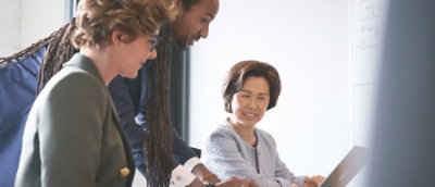 A group of people looking at a computer