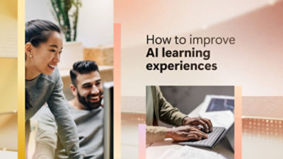 A man and woman smiling and looking at a laptop other near a white sign with black text that reads, How to improve AI learning experiences