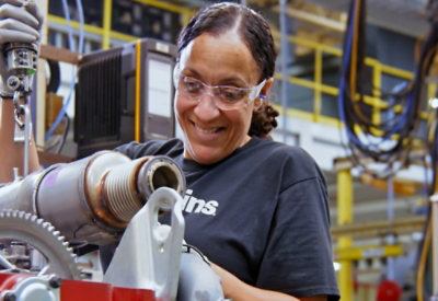 A women smiling and working with mechanical parts