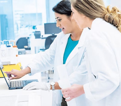 Healthcare professionals discussing patient data while reviewing information on a tablet in a clinical workspace.