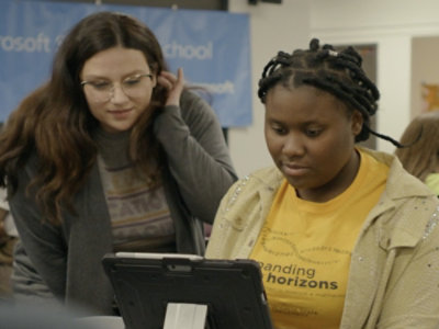 Two person's looking at a tablet.