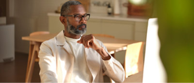 A man with glasses and a beard sitting at a table.
