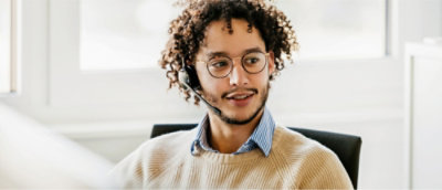 A man with curly hair wearing a headset.