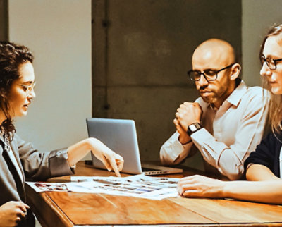 Three people reviewing documents together at a table.