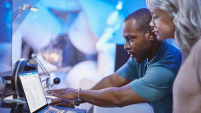 A man and woman looking at a laptop.