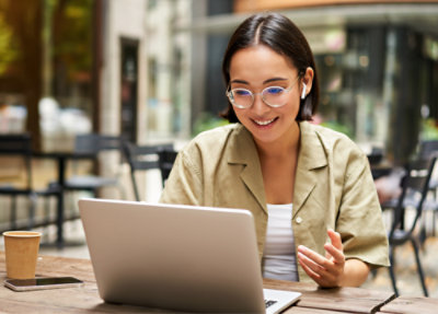 A woman sitting at a table using a laptop.