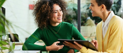 A person wearing a green shirt holding a tablet.