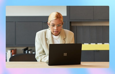 A woman in a white suit using a laptop.
