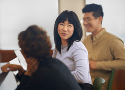 A group of people sitting in a classroom, engaging in conversation. 