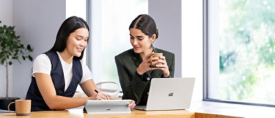 Two women working on laptop.