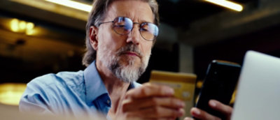 Person using a smartphone while seated indoors in a modern environment.