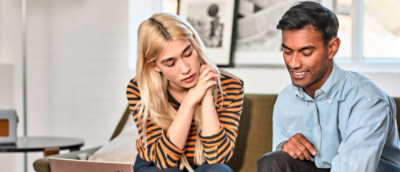 Two people seated together reviewing content in shared workspace