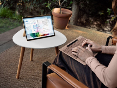 Person using a laptop at an outdoor workspace.