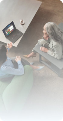Two people reviewing content on a laptop in a collaborative workspace
