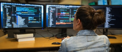 A girl looking at a computer screen and doing monitoring.