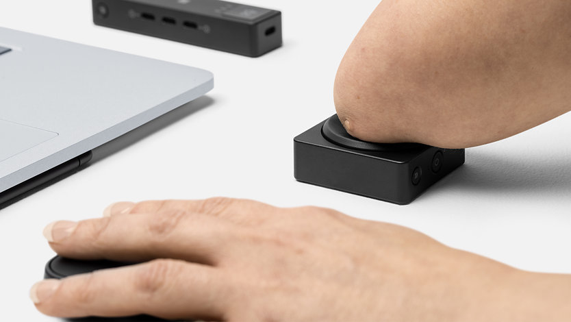 En person som har en fysisk funktionsnedsättning trycker på en Microsoft Adaptive Button.