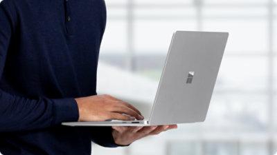 Un primer plano de una persona sosteniendo un Surface Laptop para empresas .