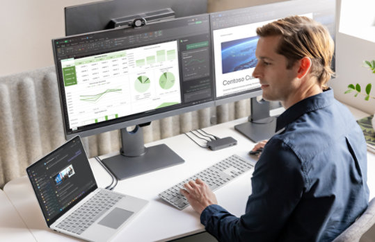 Een persoon bij een desktopopstelling gebruikt een Surface Laptop voor zakelijk gebruik, Copilot+ PC, 13 inch | Snapdragon. 