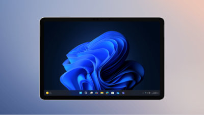 Appareil 2-en-1 affichant le système d'exploitation Windows 11 avec une illustration « fleur » bleue. La barre des tâches affiche des icônes d'applications telles que l'Explorateur de fichiers et Microsoft Edge.