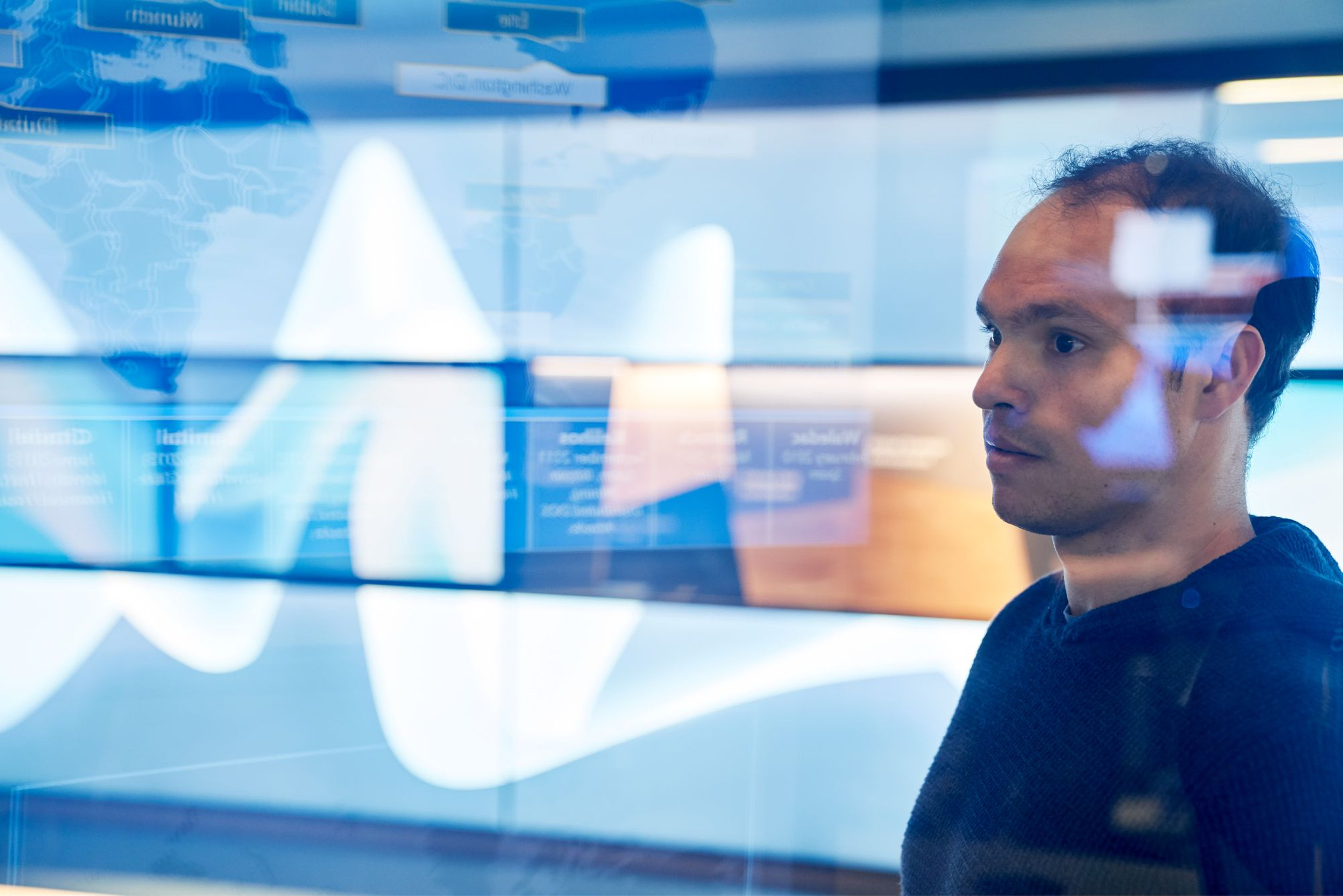 A person looking at digital screens with data visualizations 