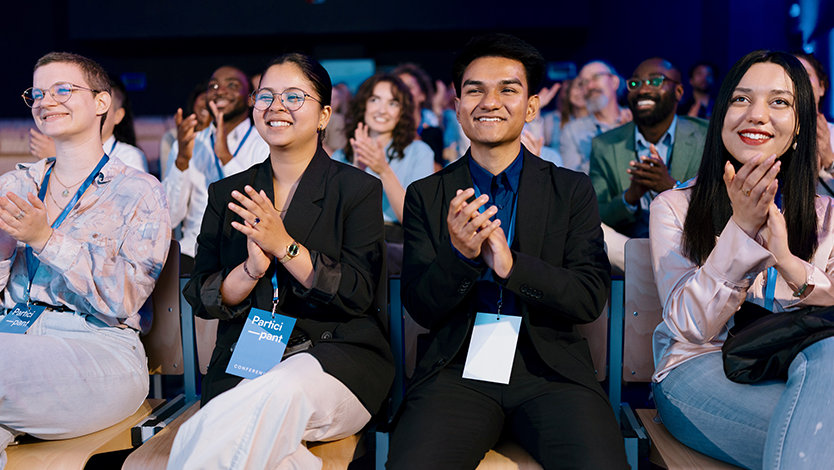 Audience applauding at a conference.