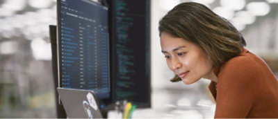 A woman with short brown hair looking at a computer screen.
